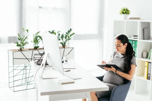 Pregnant Woman Sitting Room Bookcase Flowerpot Plants Table Taking Notes — Stock Photo, Image