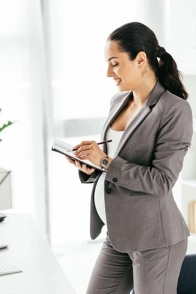 Mujer Embarazada Tomando Notas Mientras Está Pie Oficina — Foto de Stock