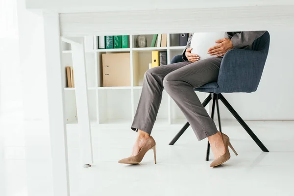 Vista Recortada Mujer Embarazada Sosteniendo Vientre Mientras Está Sentado Silla — Foto de Stock