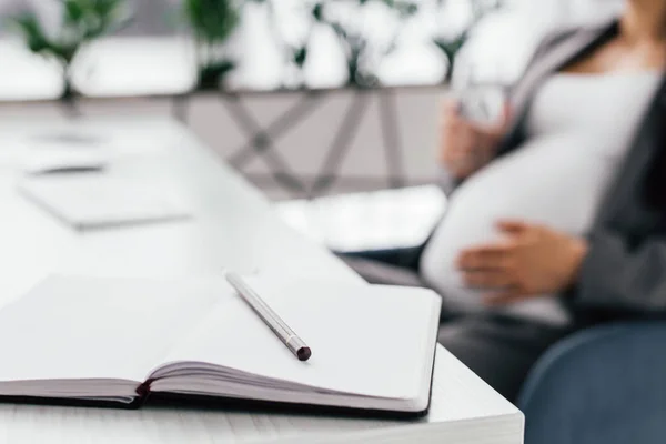 Selective Focus Notebook Pencil Table Pregnant Woman Holding Glass Water — Stock Photo, Image