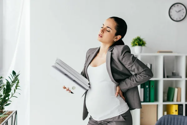Wyczerpane Kobiety Ciąży Trzymając Powrotem Wiele Folderów — Zdjęcie stockowe