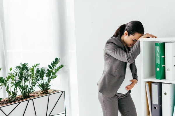 Pregnant Woman Enduring Pain Leaning Bookcase Office — Stock Photo, Image