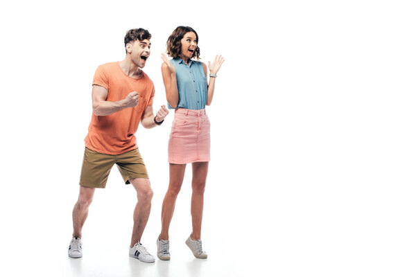 excited man and woman showing yes gestures and looking away on white background