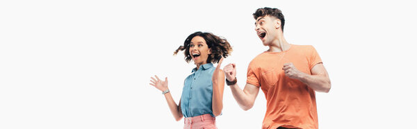 panoramic shot of happy man and woman looking away and showing triumph gestures isolated on white