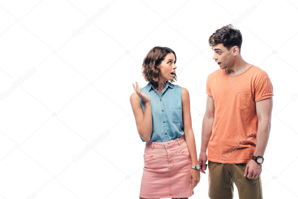 young, discouraged man and woman looking at each other isolated on white