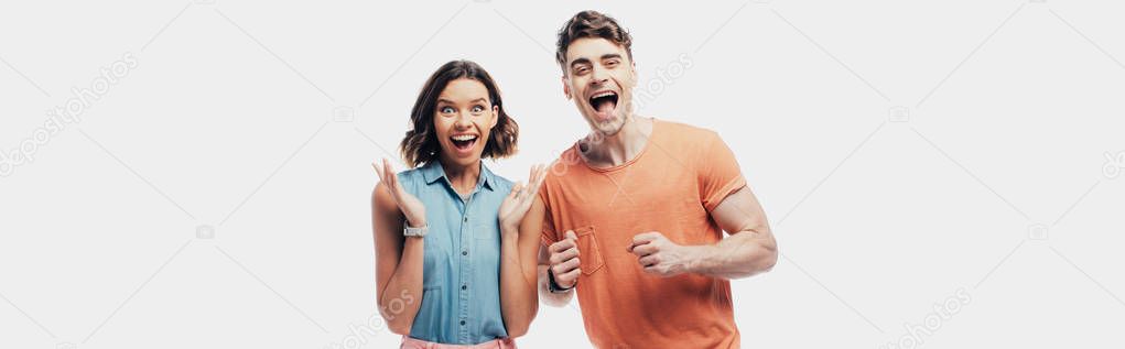 excited man and woman looking at camera and showing yes gestures isolated on grey