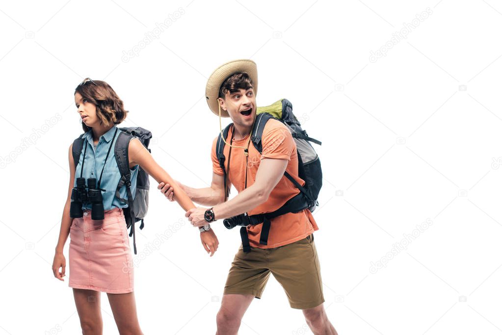 excited boyfriend holding hand of dissatisfied young woman isolated on white