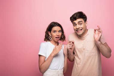 duygusal erkek ve kadın gesturing pembe arka plan üzerinde kamera bakarken sus