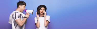 mavi arka plan üzerinde akıllı telefon konuşurken kız arkadaşı hoparlörde kavga sinirli adam panoramik çekim
