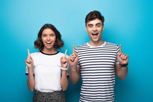 Cheerful Man Woman Pointing Fingers Looking Camera Blue Background — Stock Photo, Image