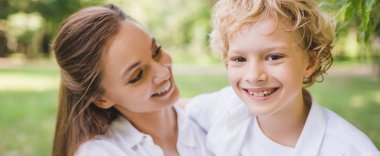 parkta gülümseyen sevimli oğlu ile güzel anne panoramik çekim