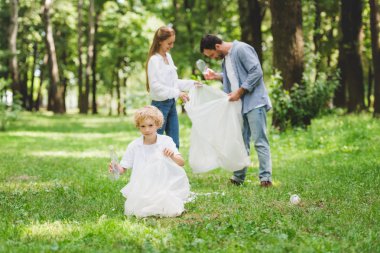 aile gündüz parkta plastik torbalarda çöp toplama