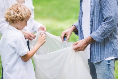 parkta plastik torba içinde çöp toplama aile kırpılmış görünümü