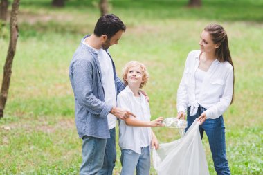 parkta plastik torba içinde çöp toplama rahat giysiler aile
