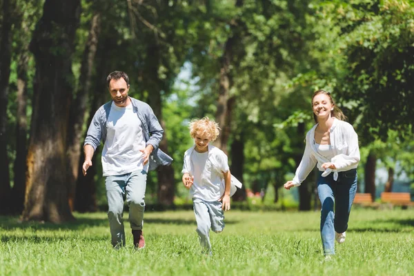 Família Feliz Correndo Parque Durante Dia Olhando Para Câmera — Fotografia de Stock