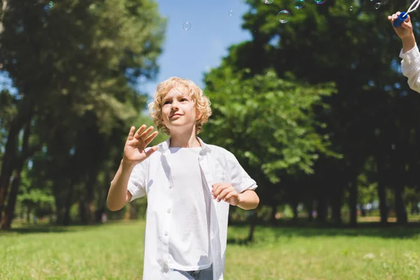 Parkta Sabun Kabarcıkları Yakınında Beyaz Gesturing Sevimli Çocuk — Stok fotoğraf