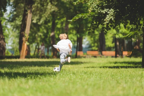 昼間に公園でサッカーをしている少年のバックビュー — ストック写真