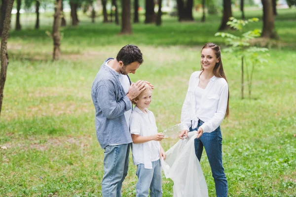 Famiglia Abiti Casual Raccogliendo Spazzatura Sacchetto Plastica Nel Parco — Foto Stock