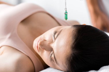 woman with closed eyes and green stone above her head clipart