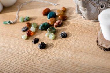 bright colorful semiprecious stones on brown wooden surface clipart