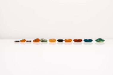 colorful semiprecious stones on white surface isolated on grey clipart