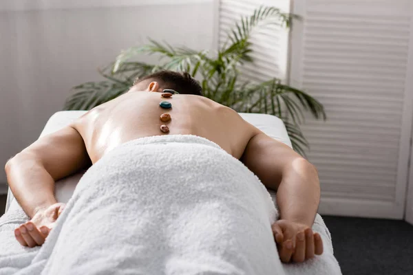 Shirtless Man Lying Massage Table Stones Back — Stock Photo, Image