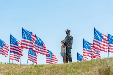 amerikan bayrakları yakınında sevimli çocuk ile ayakta askeri üniformalı baba seçici odak 