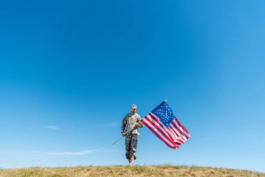 yıldız ve çizgili Amerikan bayrağı ile yürüyüş üniformalı yakışıklı askeri adam 