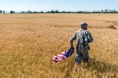 Amerikan bayrağı tutan askeri üniformalı yakışıklı adam 