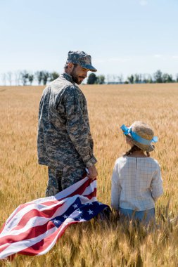 yakışıklı asker alanında Amerikan bayrağı tutarken kızı bakıyor 