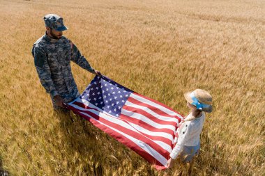 üniformalı asker ve alanda Amerikan bayrağı tutan çocuk havai görünümü 