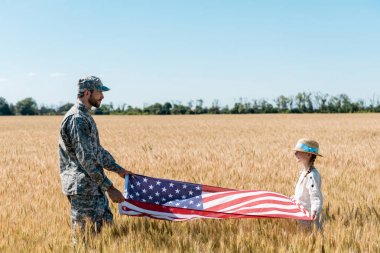 üniformalı asker ve neşeli çocuk alanında Amerikan bayrağı tutan 