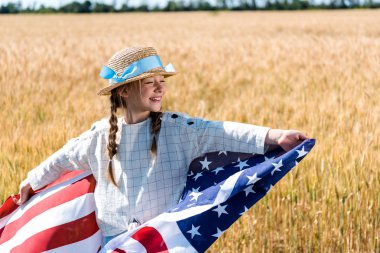 altın alanda yıldız ve çizgili amerikan bayrağı tutan neşeli çocuk 