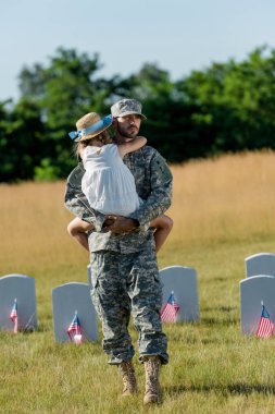 amerikan bayrakları ile mezar taşları yanında hasır şapka ams çocuk tutan kap askeri adam 