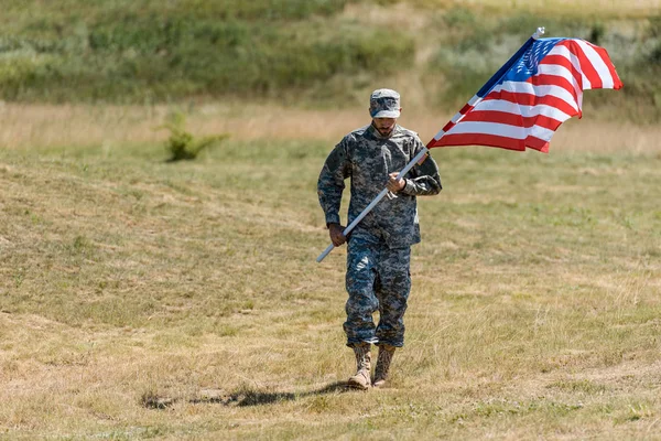 夏の間に歩いてアメリカの旗を持つ兵士の選択的な焦点 — ストック写真