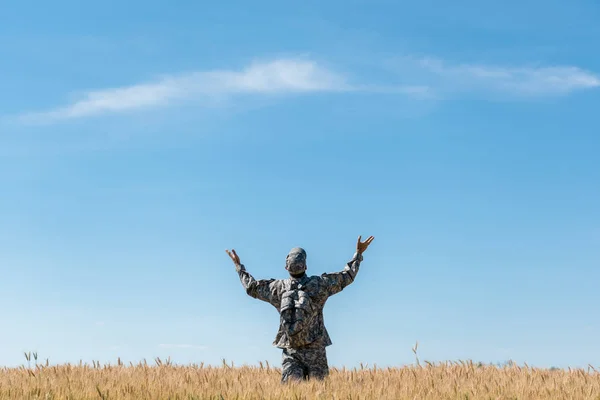 Visão Traseira Soldado Uniforme Militar Com Mãos Estendidas Campo Com — Fotografia de Stock