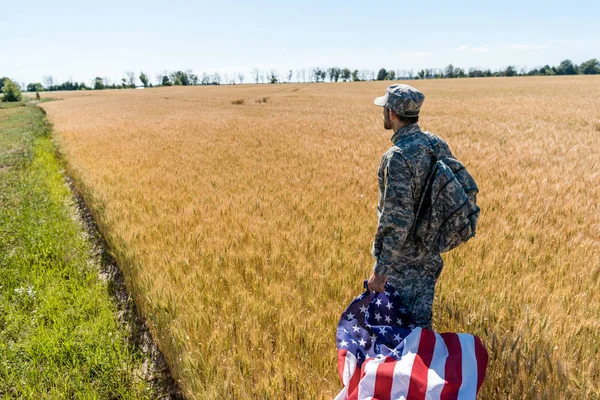 フィールドに立っている間 アメリカの旗を持つ軍服を着たハンサムな男 — ストック写真