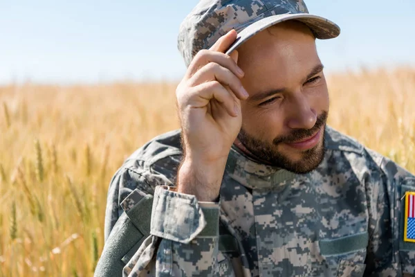 Homem Militar Alegre Tocando Boné Sorrindo Campo — Fotografia de Stock