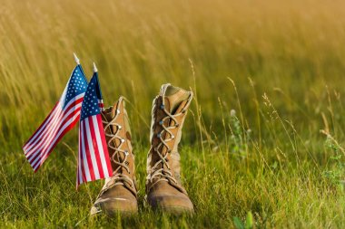çim üzerinde yıldız ve çizgili Amerikan bayrağı yakınında askeri botlar 