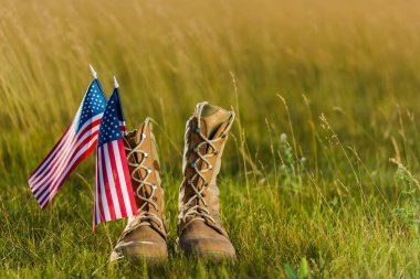military boots near american flag with stars and stripes on grass  clipart