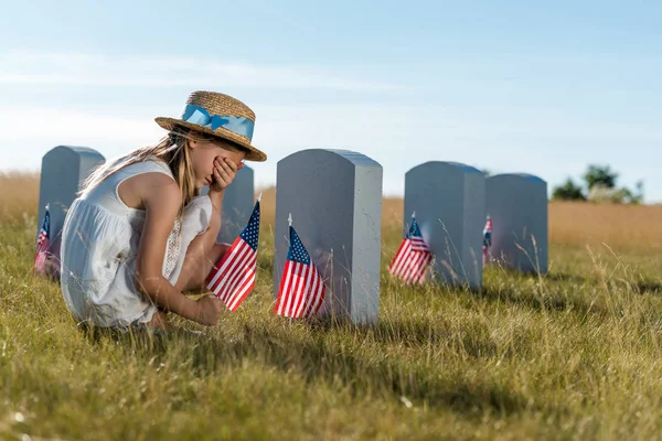 Kid Straw Hat Covering Face While Sitting Headstones American Flags — Stock Photo, Image