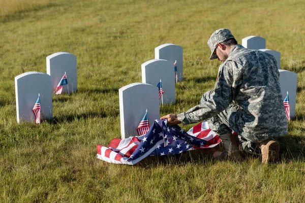 Soldat Uniforme Camouflage Casquette Tenant Drapeau Américain Assis Dans Cimetière — Photo