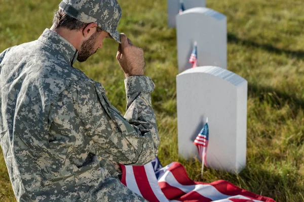 Foco Seletivo Soldado Camuflagem Touching Cap Uniforme Enquanto Sentado Cemitério — Fotografia de Stock