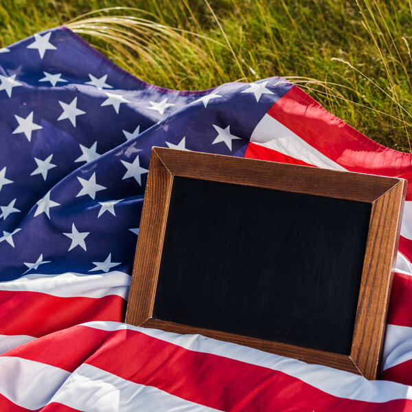 close up of empty chalkboard on american flag with stars and stripes 