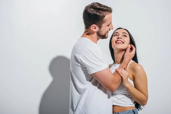 Jovem Reajustando Cabelo Namorada Enquanto Sorrindo Abraçando Outro — Fotografia de Stock