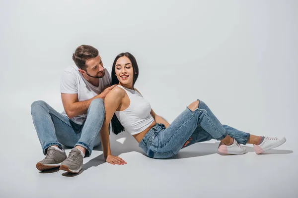 Casal Bonito Sentado Chão Sorrindo Olhando Para Outro — Fotografia de Stock