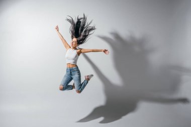 full length view of excited girl jumping with hands in air  clipart