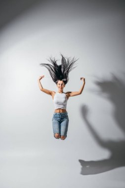 havada eller ile atlama heyecanlı mutlu kız tam uzunlukta görünümü 