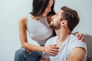 yakın otururken birbirlerine bakarak aşık genç çift 