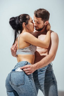seksi çift sarılmak ve adam kız kot prezervatif koyarak iken öpmek için çalışıyor